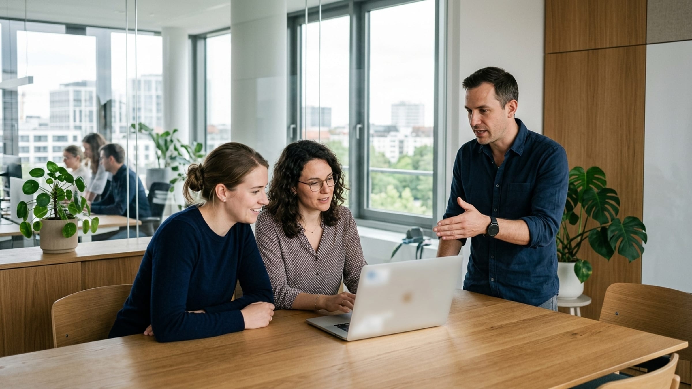 A software demo: two or three people around a laptop, one presenting, the others engaged.